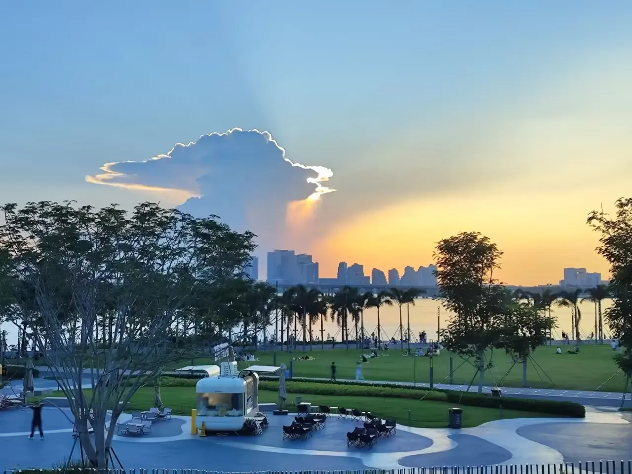 
这天突然飘来一大朵云，刚好把太阳给遮住了，然后阳光透过云层，洒向两侧，沙滩落日、广场静谧，草坪浓绿，一切都刚刚好。
